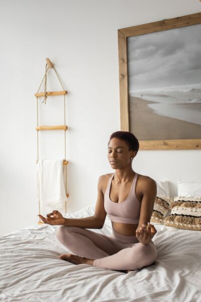 black woman meditating on bed