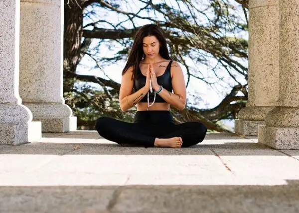 woman meditating outside in stone structure